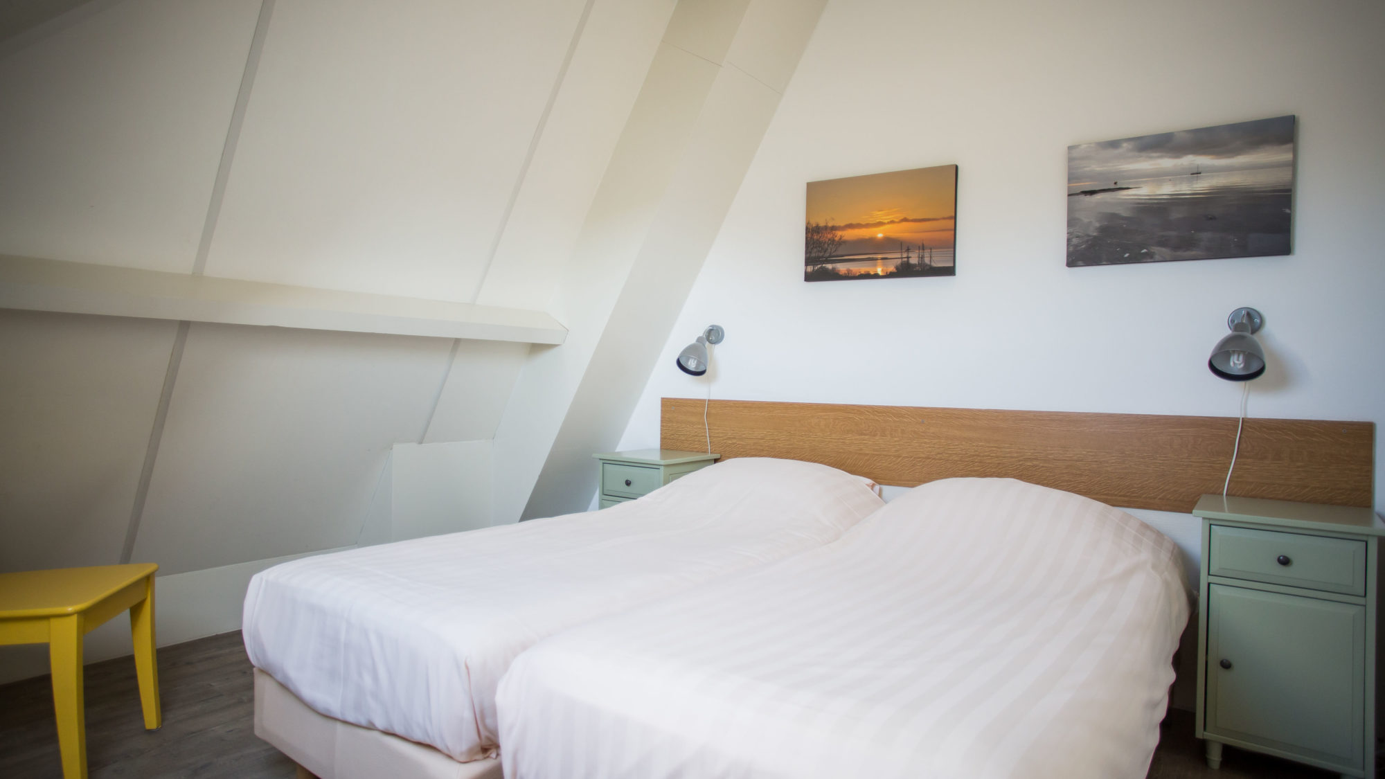 Schuin dak en litsjumeaux nachtkast leeslampje Studio etage Hotel Tjermelan Terschelling