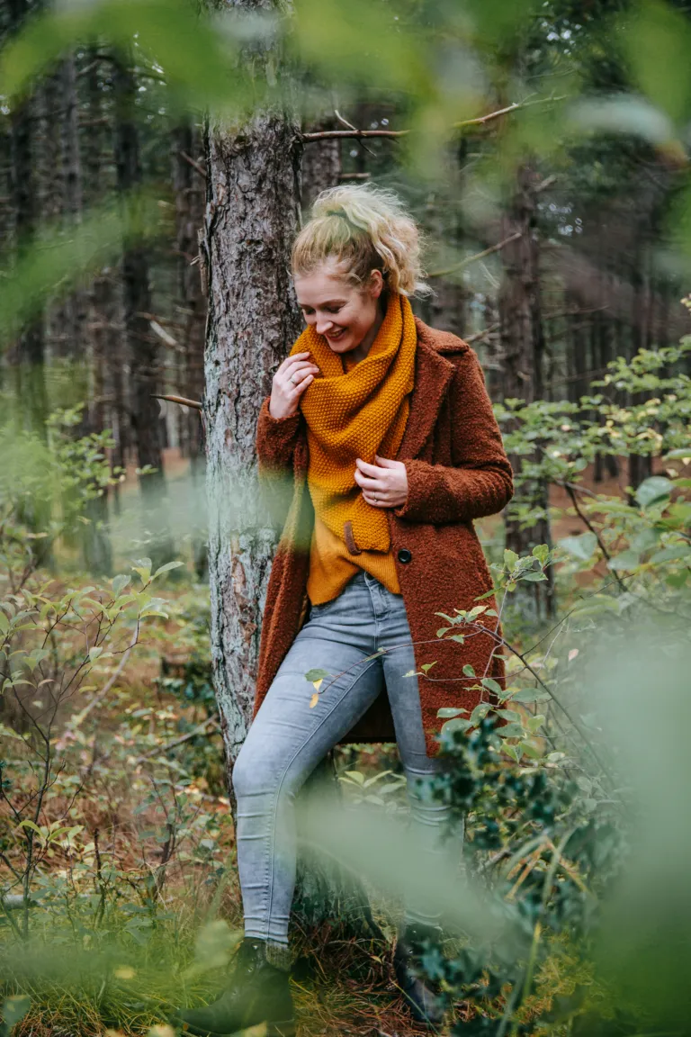 Een vrouw wandelt door een herfstig bos op Waddeneiland Terschelling