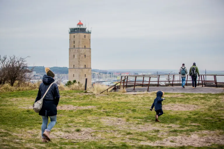 vuurtoren Brandaris enkele mensen lopen over het hoge duin uitzicht op de haven van West-Terschelling