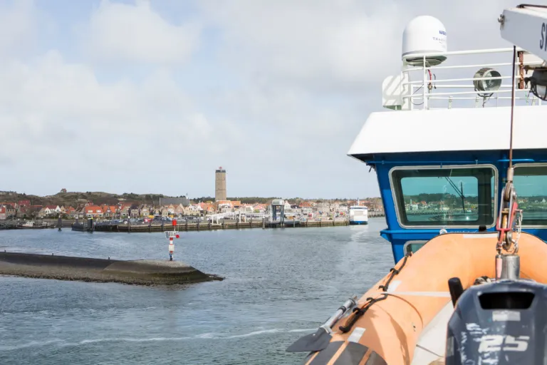 Aanzicht dorp en Brandaris havenhoofd vanaf de veerboot vakantiehuis bungalow Terschelling Recreatie